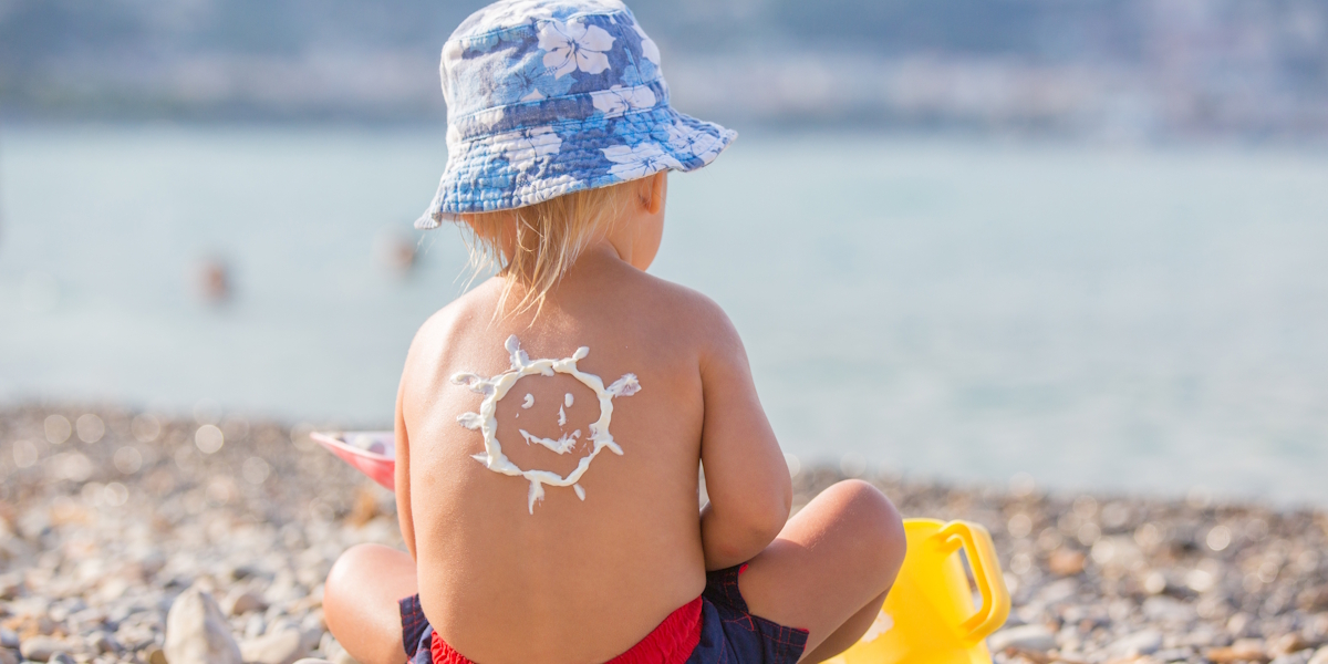 Kleiner Junge spielt am Strand im Sand.