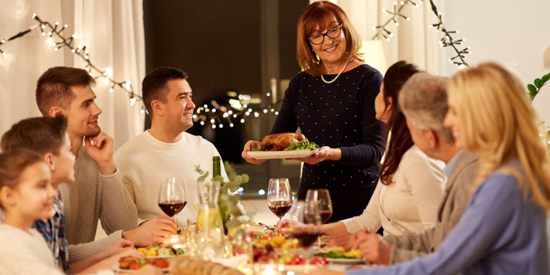 Die Familie hat sich um den schön gedeckten Tisch versammelt.