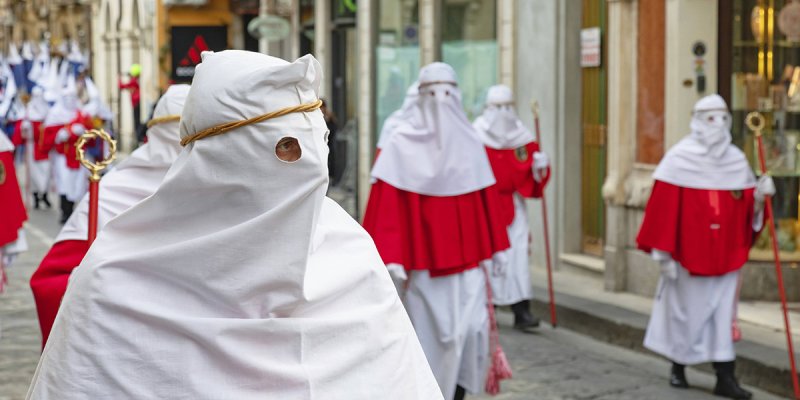 Personen mit Masken bei der Krafreitagsprozession in den Straßen von Enna, Sizilien
