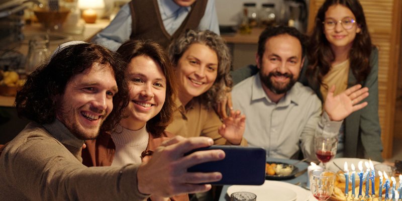 eine Gruppe Jüdinnen und Juden machen ein Selfie und winken in die Kamera